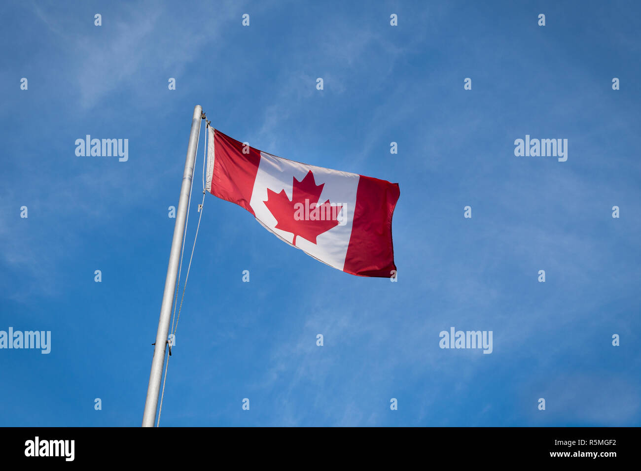 Waving Canadian flag against the blue sky. Stock Photo