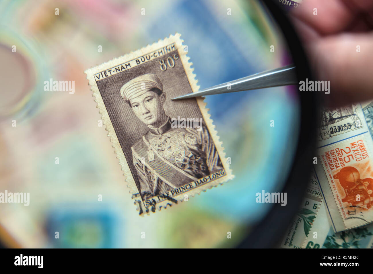A old Vietnam Republic stamp depicting Prince Bao Long under the magnifying glass. Stock Photo