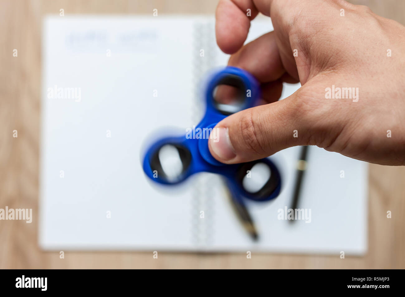 open notebook for home work distracting spinner Stock Photo