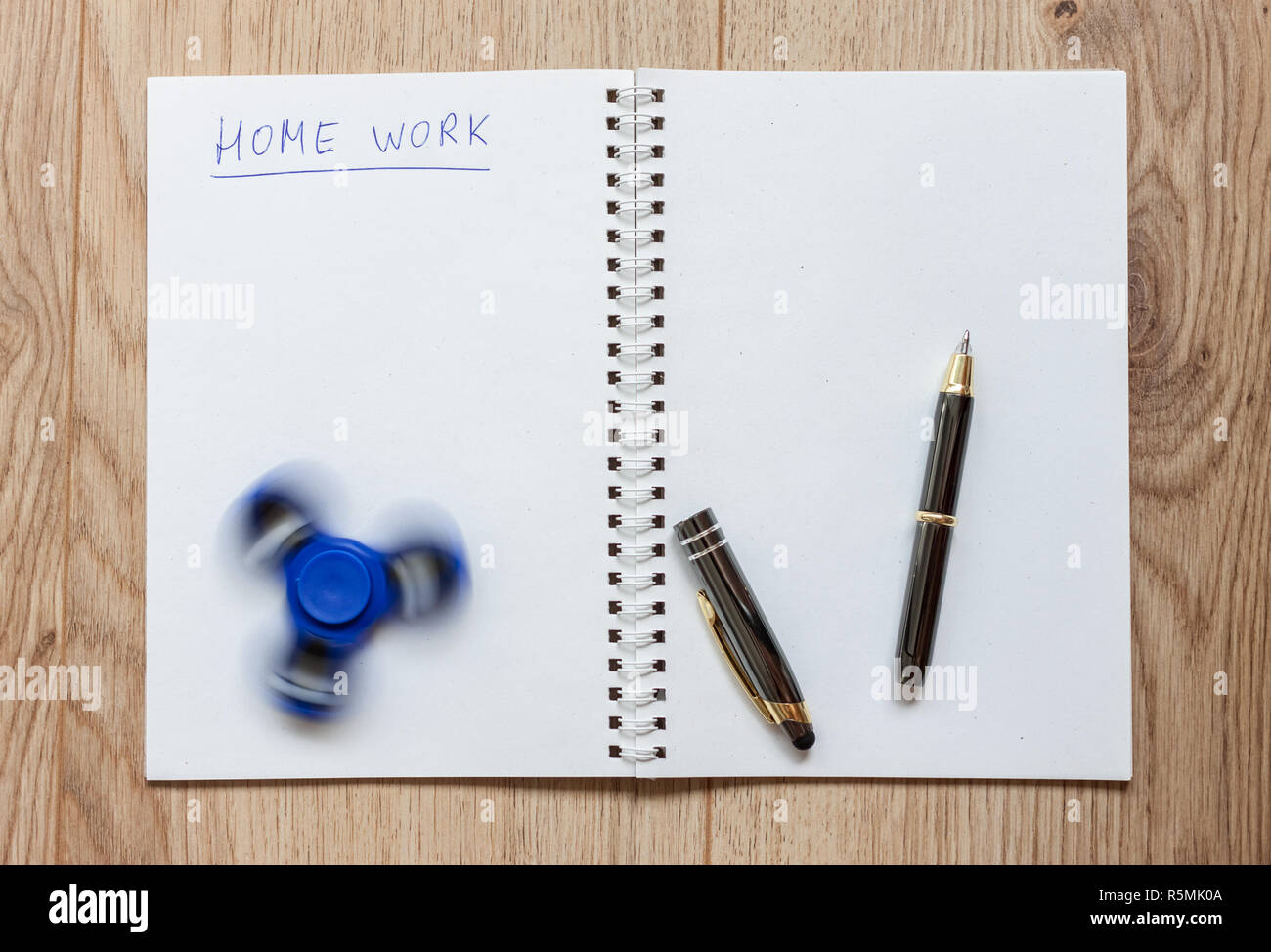 open notebook for home work distracting spinner Stock Photo