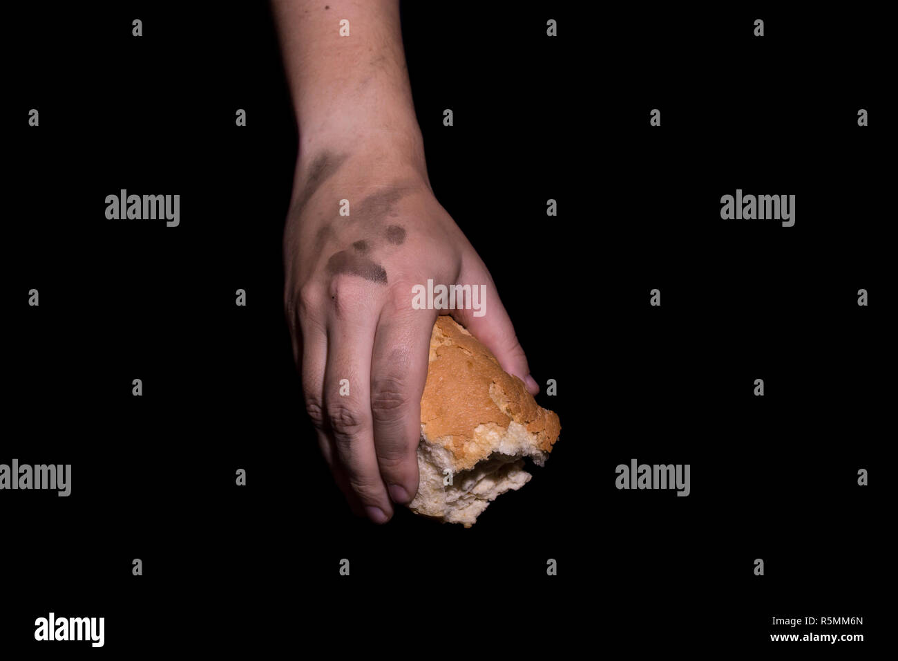 Poverty concept. Hands holding bread isolated on balck background. Stock Photo