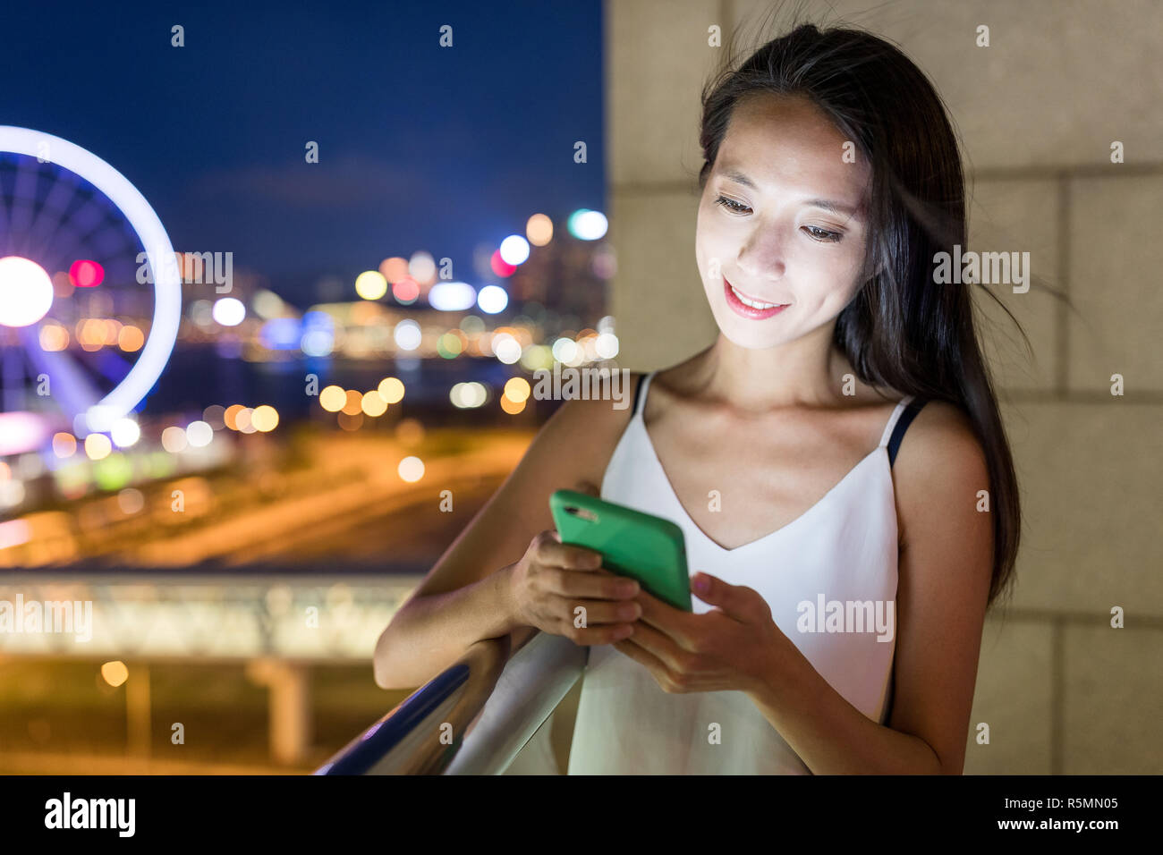 Woman looking at mobile phone at night Stock Photo - Alamy