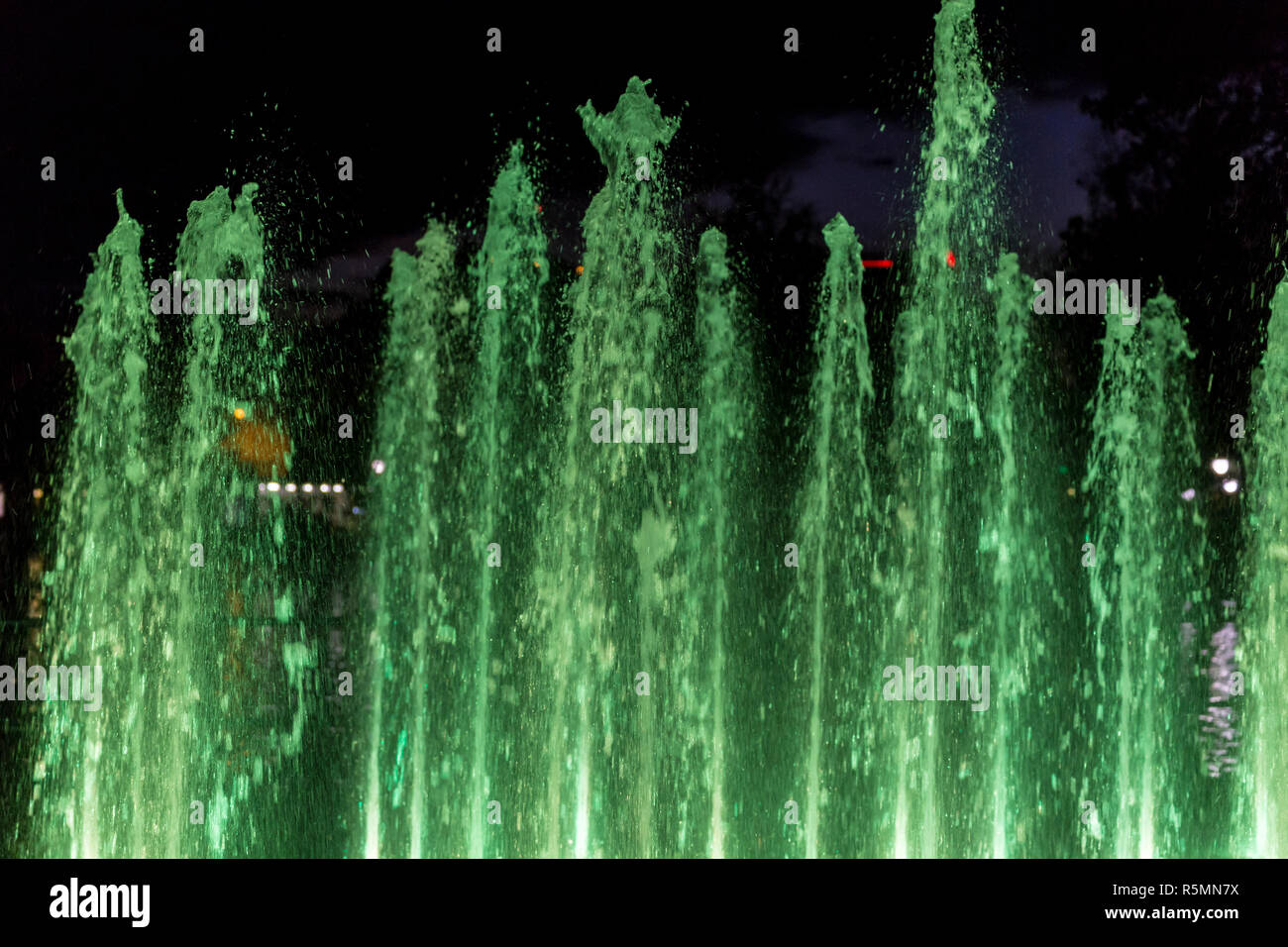 Colorful fountain water spray at night Stock Photo - Alamy