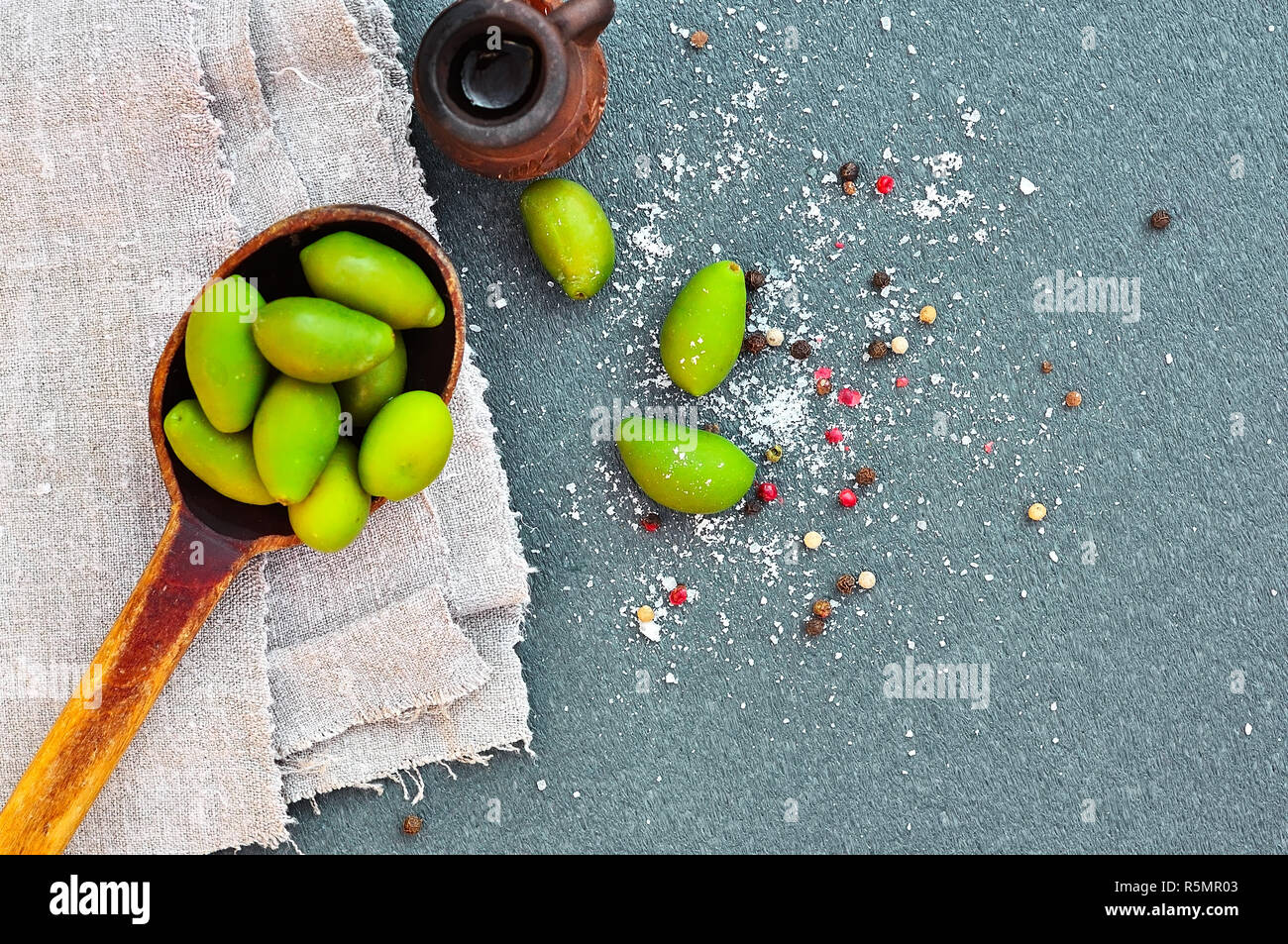 Green olives in a wooden spoon Stock Photo - Alamy
