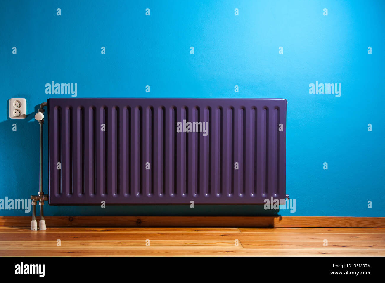 Purple radiator and a blue wall Stock Photo - Alamy