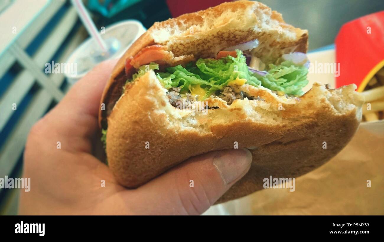 Hamburger in hand Stock Photo