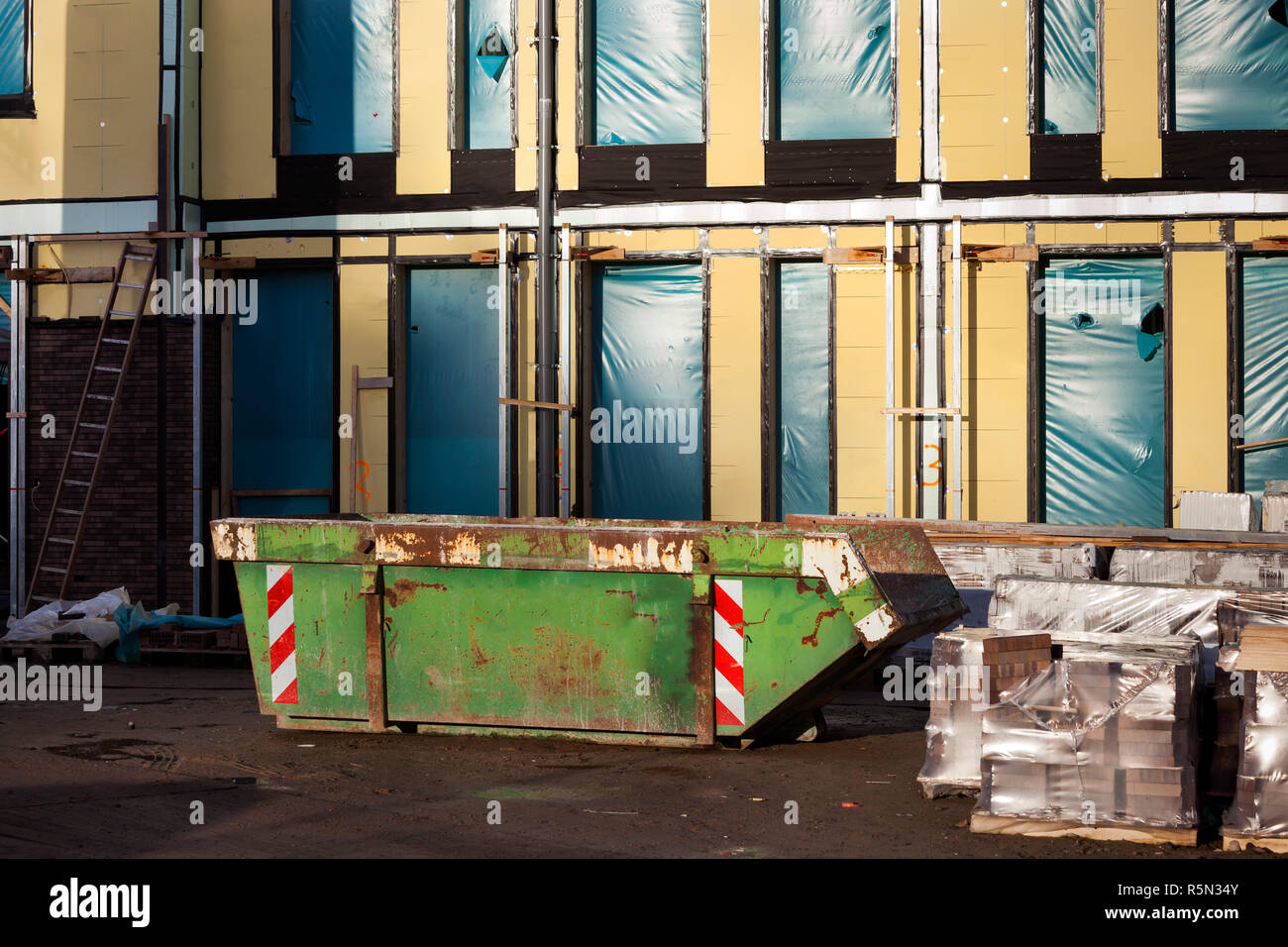 Skip on a construction site Stock Photo - Alamy