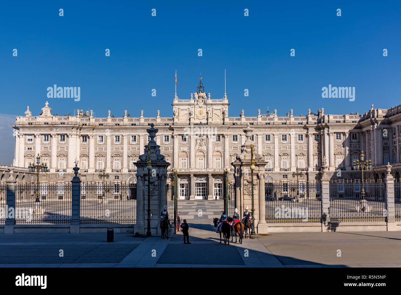 Madrid, Spain - November 29, 2018: The Royal Palace in Madrid at a cold sunny autuum day, with guards on horseback. Stock Photo