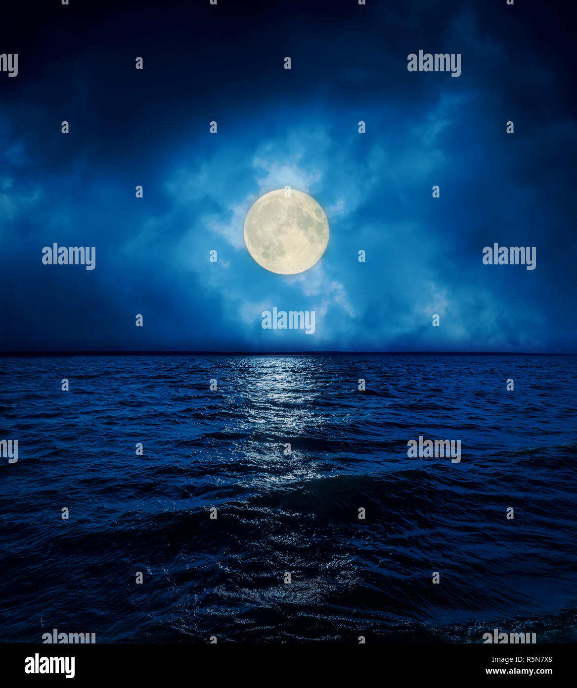 full super moon in dramatic clouds over dark water Stock Photo Alamy