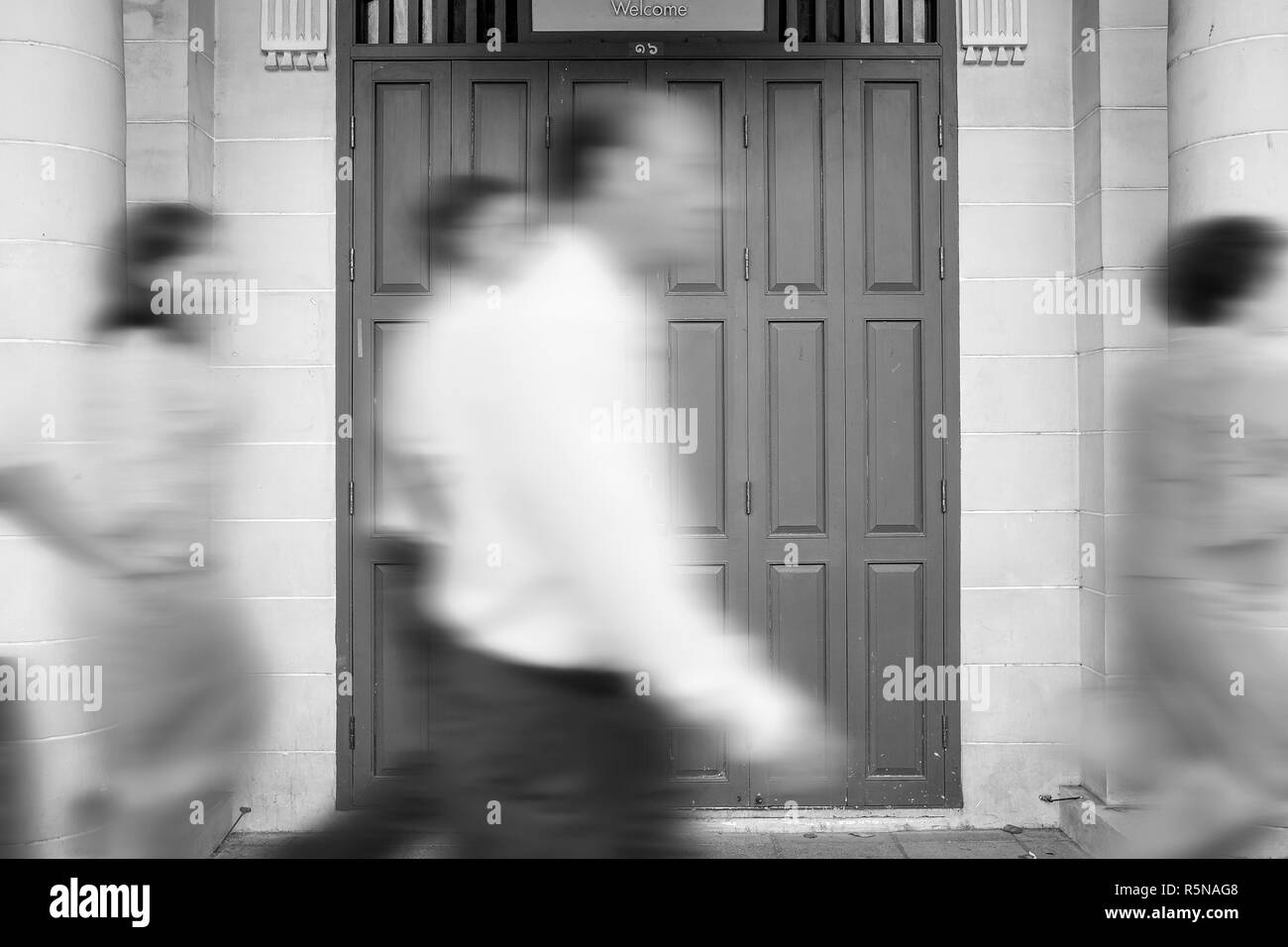 Motion blur people walking pass door of old building in rush hour  representing urban life Stock Photo - Alamy