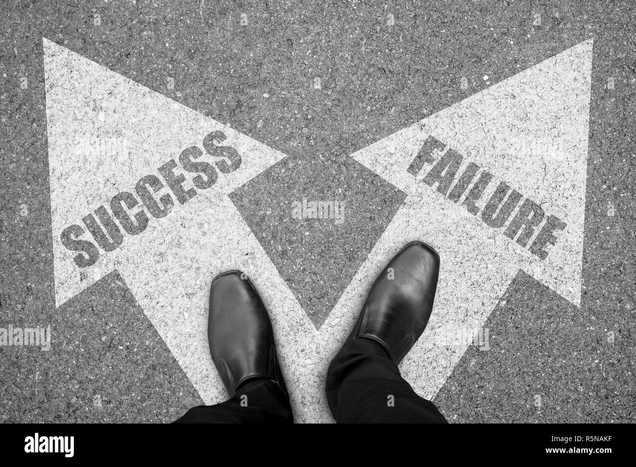 Businessman standing at the crossroad making decison which way to go - success or failure. Stock Photo