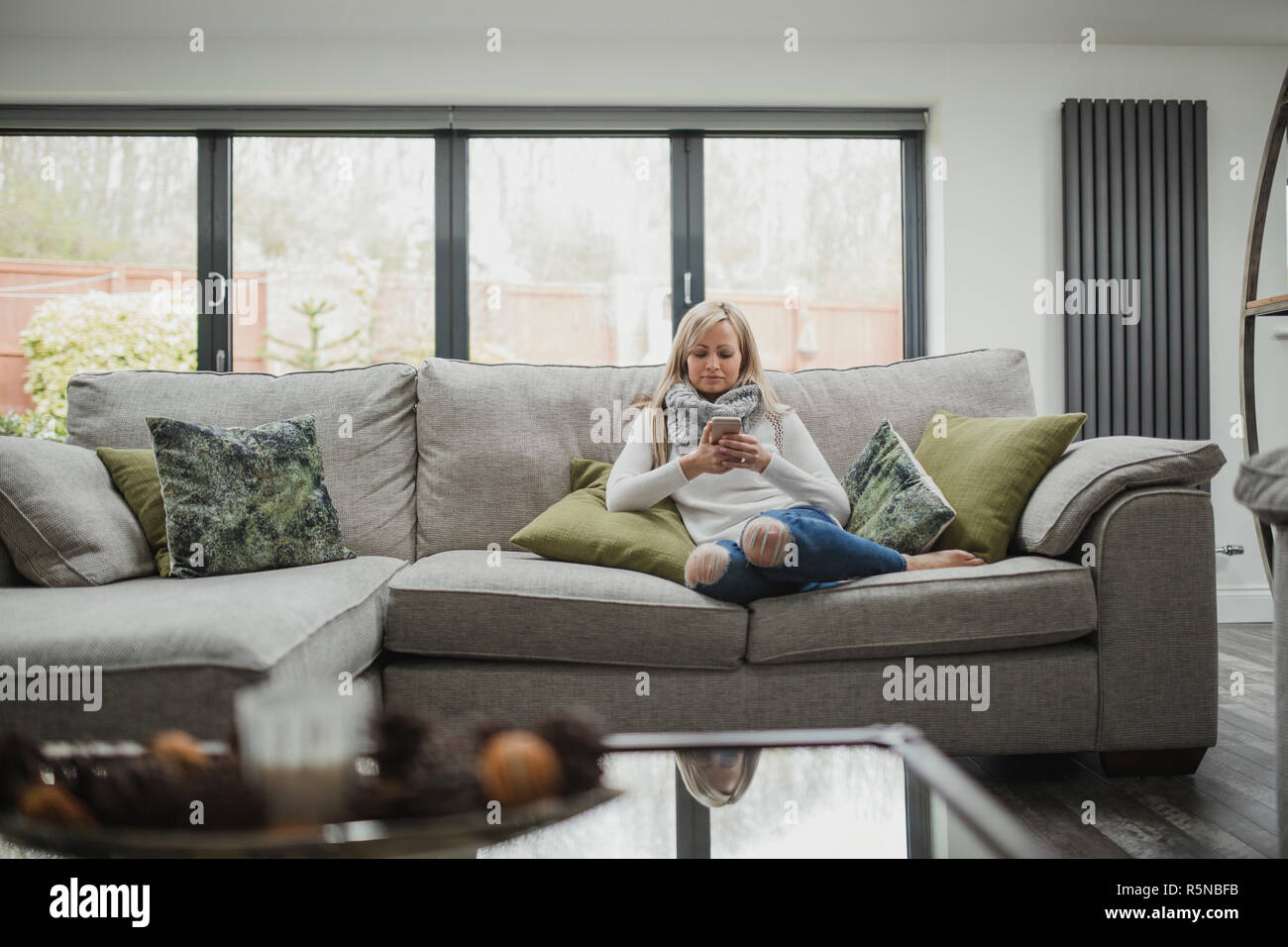Woman Using Smartphone At Home Stock Photo
