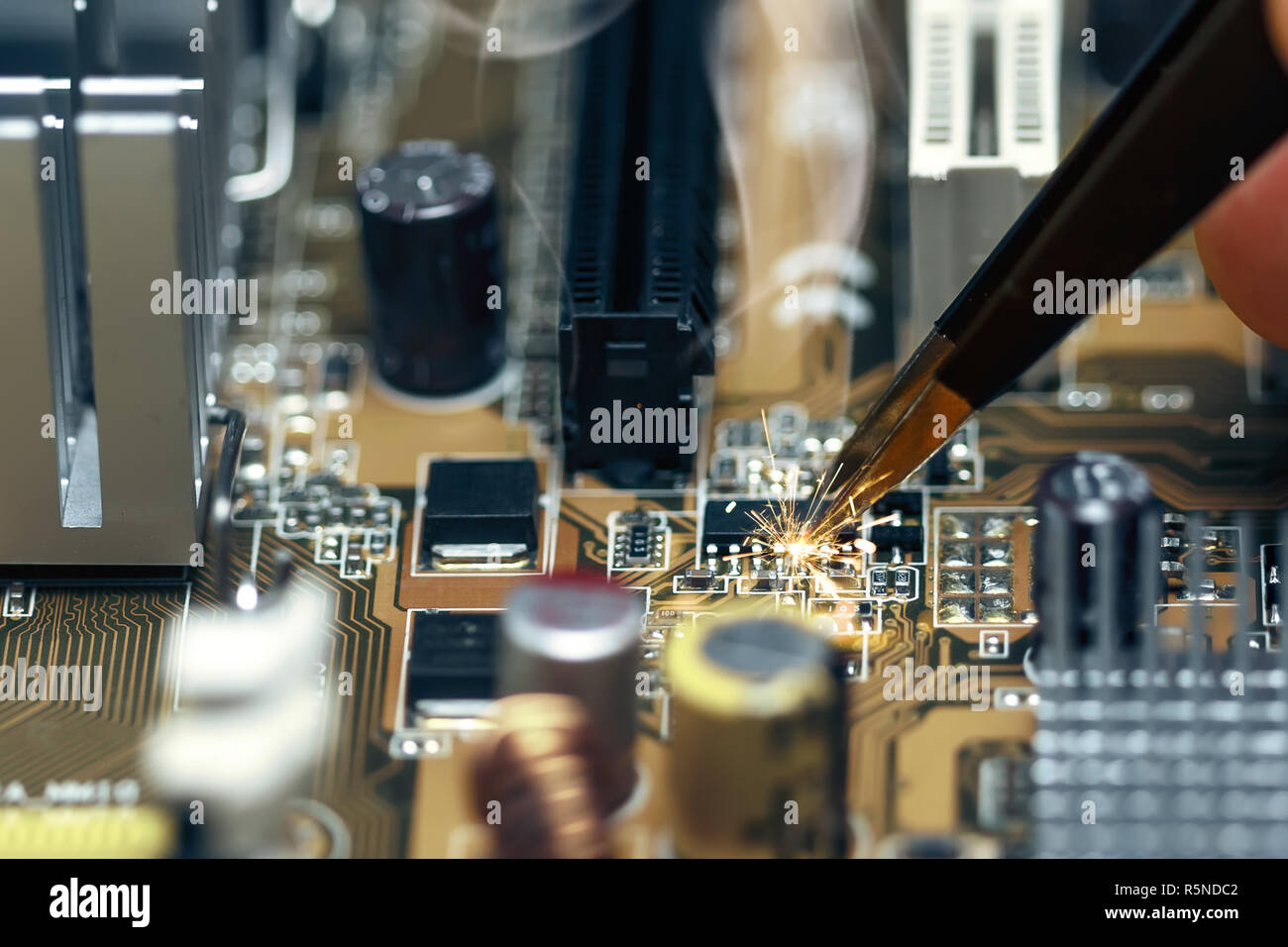 Short circuit on the motherboard during repair Stock Photo - Alamy