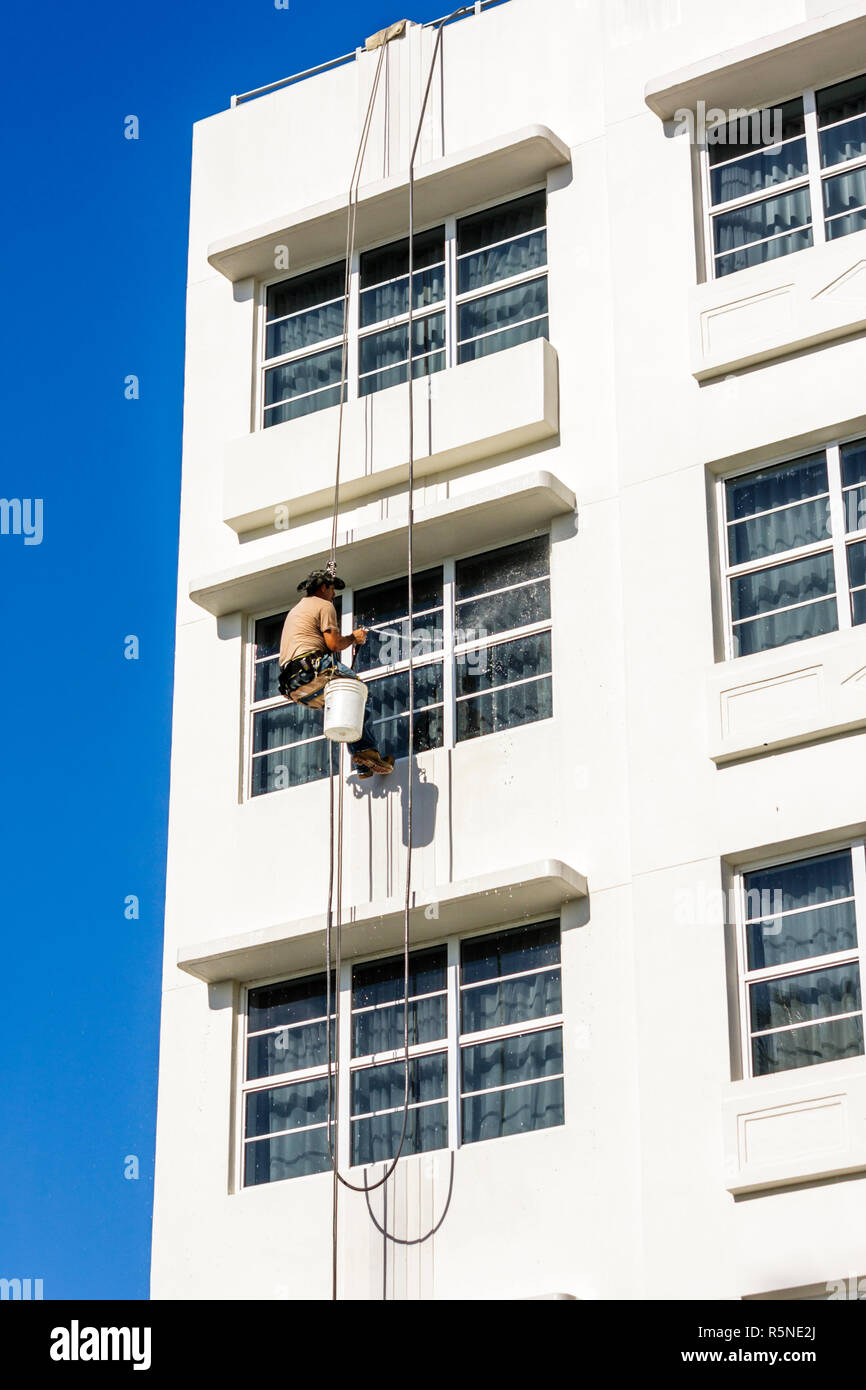 Miami Beach Florida,Ocean Drive,building,scaffold,suspended,harness,man men male adult adults,workman,window washer,cleaner,working,work,servers emplo Stock Photo