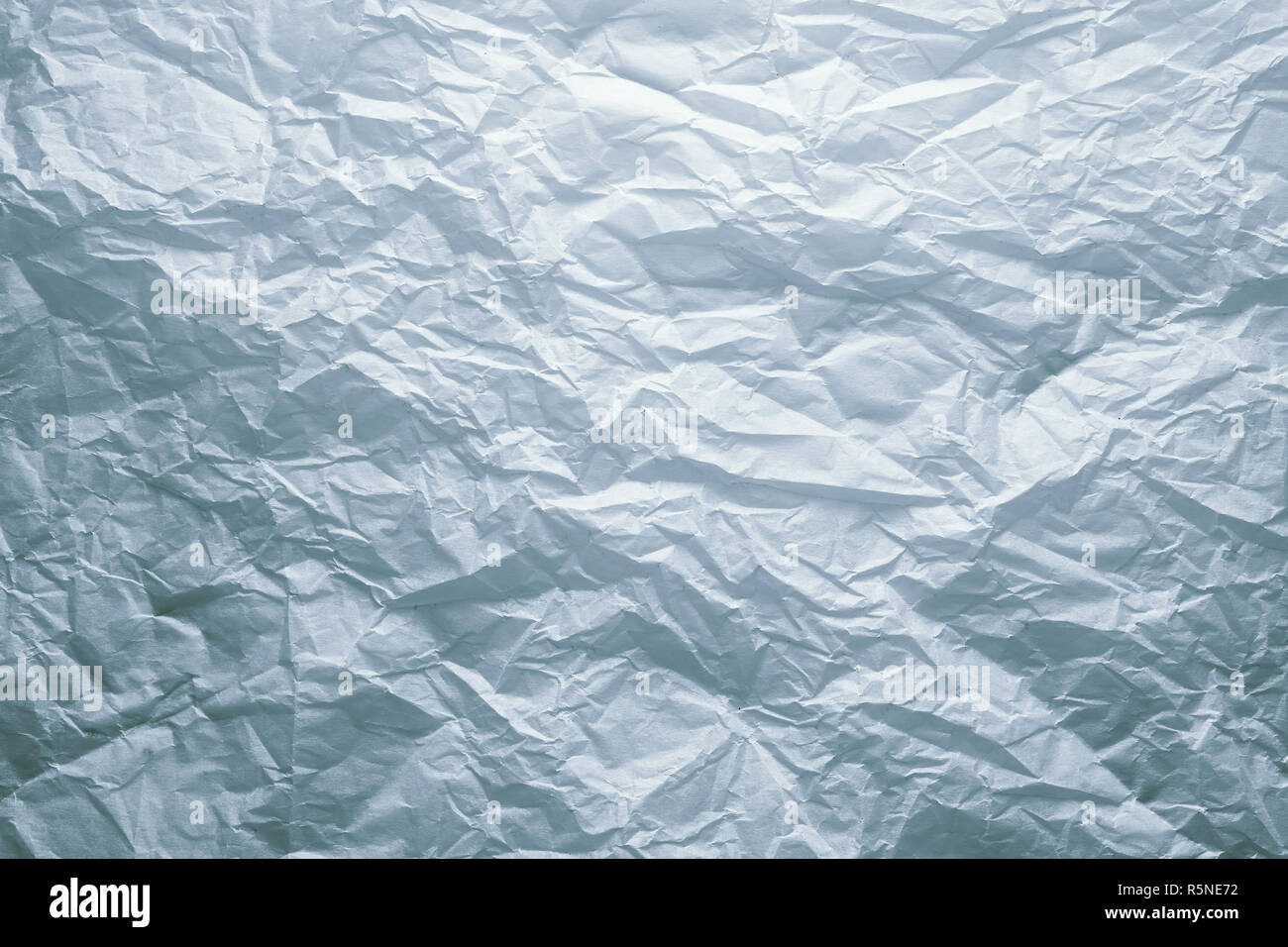 Crumpled white paper sheet background under dramatic dark moody ...