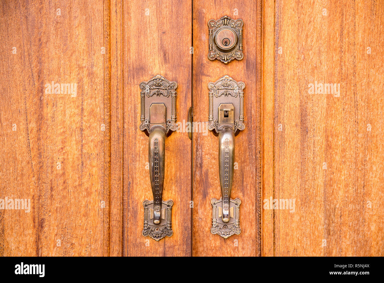 Vintage brass door handle with lock on wooden door Stock Photo