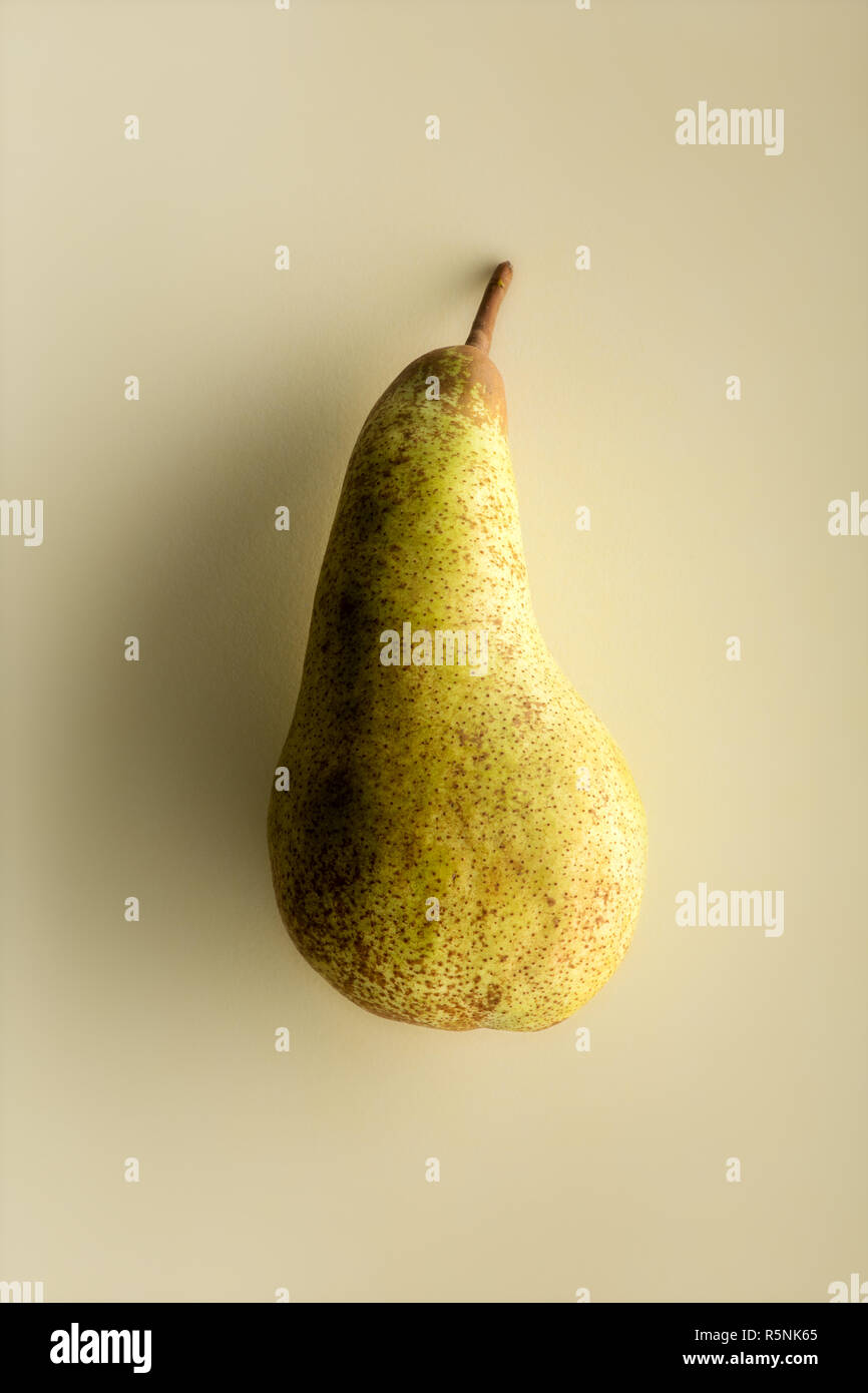 Whole ripe pear isolated on beige background, viewed from its side ...