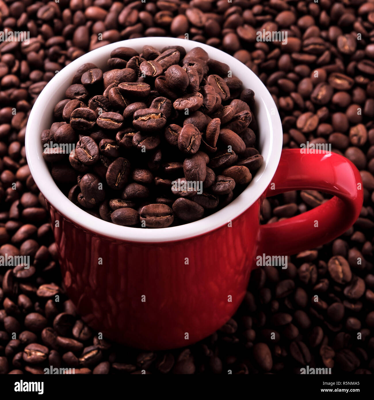 Red coffee mug filled with beans Stock Photo