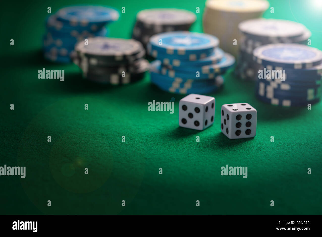 Casino, gambling concept. Poker chips piles and dice on green felt