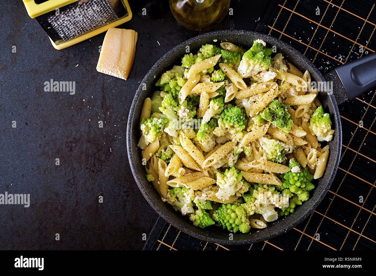 Penne pasta with cabbage romanesco on black table. Vegetarian food. Italian menu. Top view. Flat