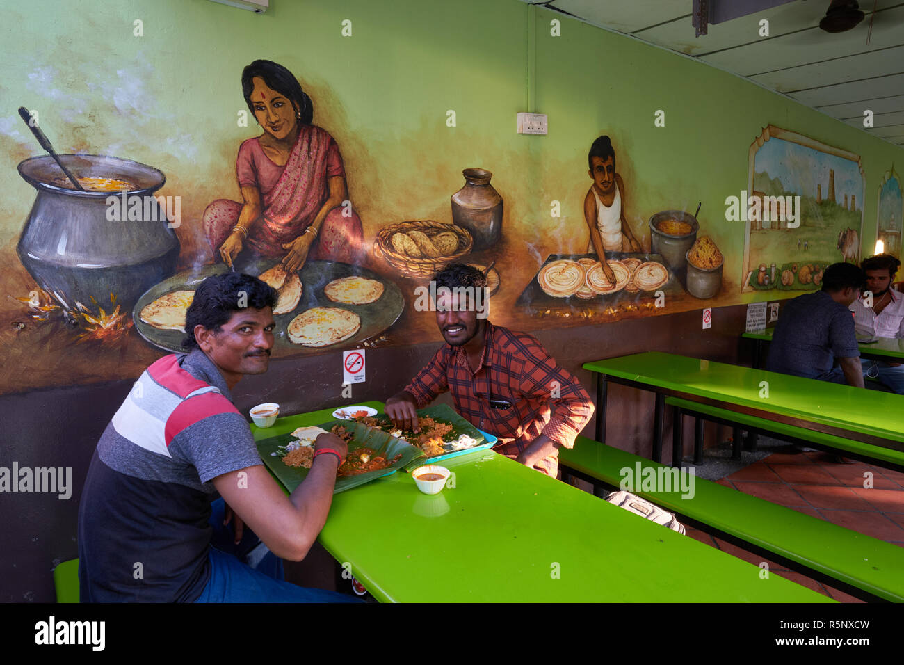Two workers from Tamil Nadu, India, at an inexpensive, traditional South Indian restaurant in the Little India area of Singapore Stock Photo
