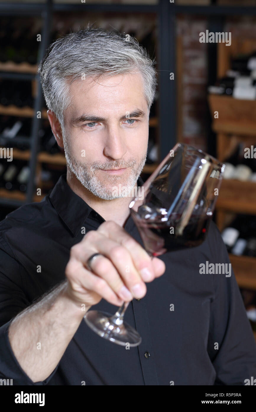 Sommelier tasting red wine. Wine cellar, men tasting red wine