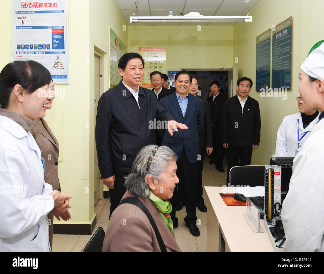 Kunming, China's Yunnan Province. 29th Nov, 2018. Li Zhanshu, a member of the Standing Committee of the Political Bureau of the Communist Party of China Central Committee and chairman of the National People's Congress Standing Committee, talks with doctors and patients in a healthcare center in Qianwei community of Xishan District of Kunming City, southwest China's Yunnan Province, Nov. 29, 2018. Li made a research on how to better make a law on basic medical care and health promotion during his four-day tour to Yunnan Province. Credit: Shen Hong/Xinhua/Alamy Live News Stock Photo