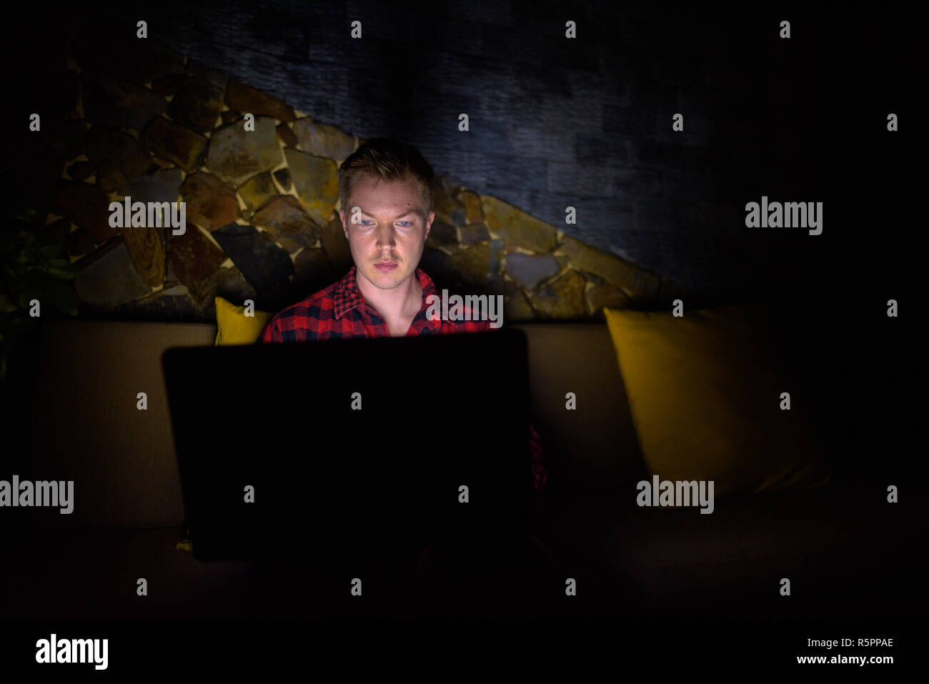 Man sitting and using laptop computer at night Stock Photo