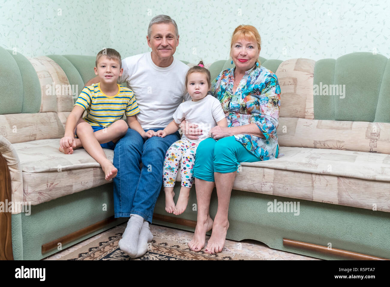 portrait of grandmothers and grandfathers with grandchildren sitting on the couch Stock Photo