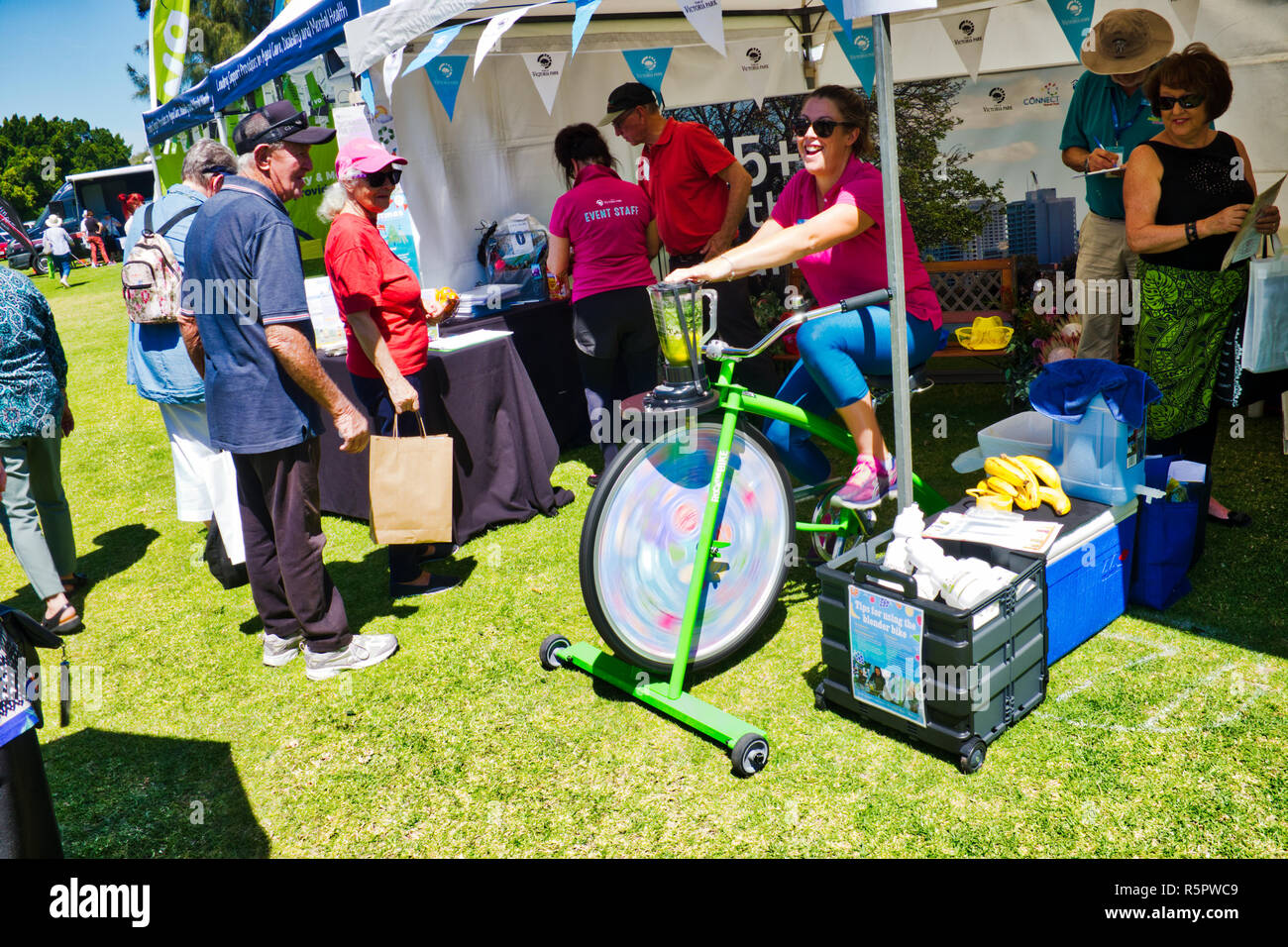 lady demonstrates pedal power blender as exercise for seniors Stock