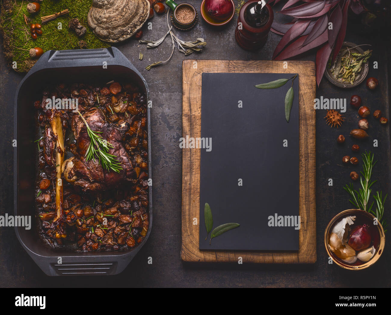 Slow cooked venison roast in black cast iron pan, top view. Braised leg