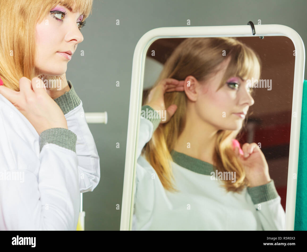 Pretty Happy Woman In Mirror Adjusting Hair With Clothing From New