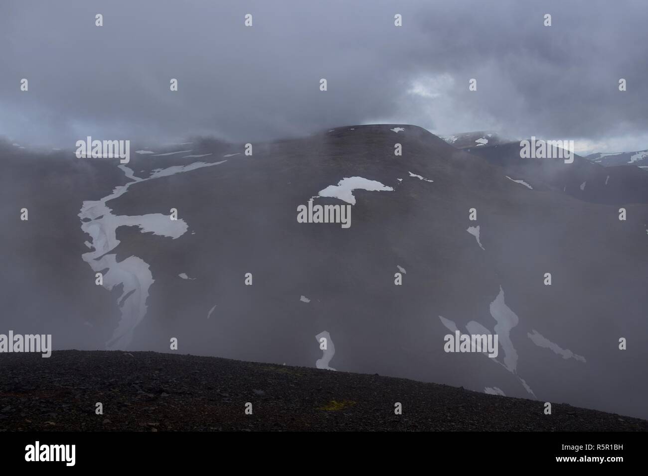 Icelandic landscape. On top of the Svinadalsfjall with bad weather conditions. Clouds coming close. Stock Photo
