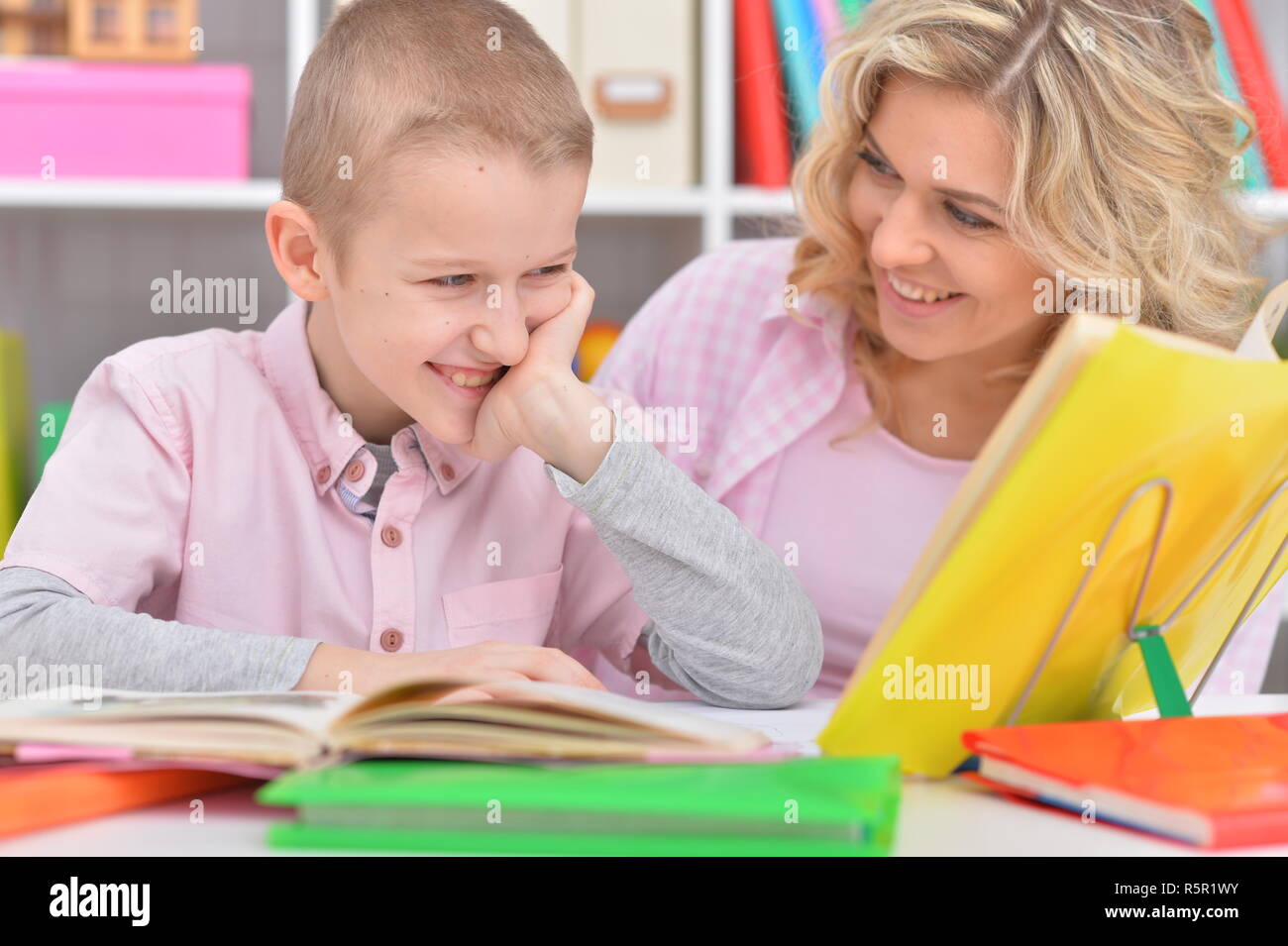 Portrait of mother with her son doing homework at home Stock Photo - Alamy