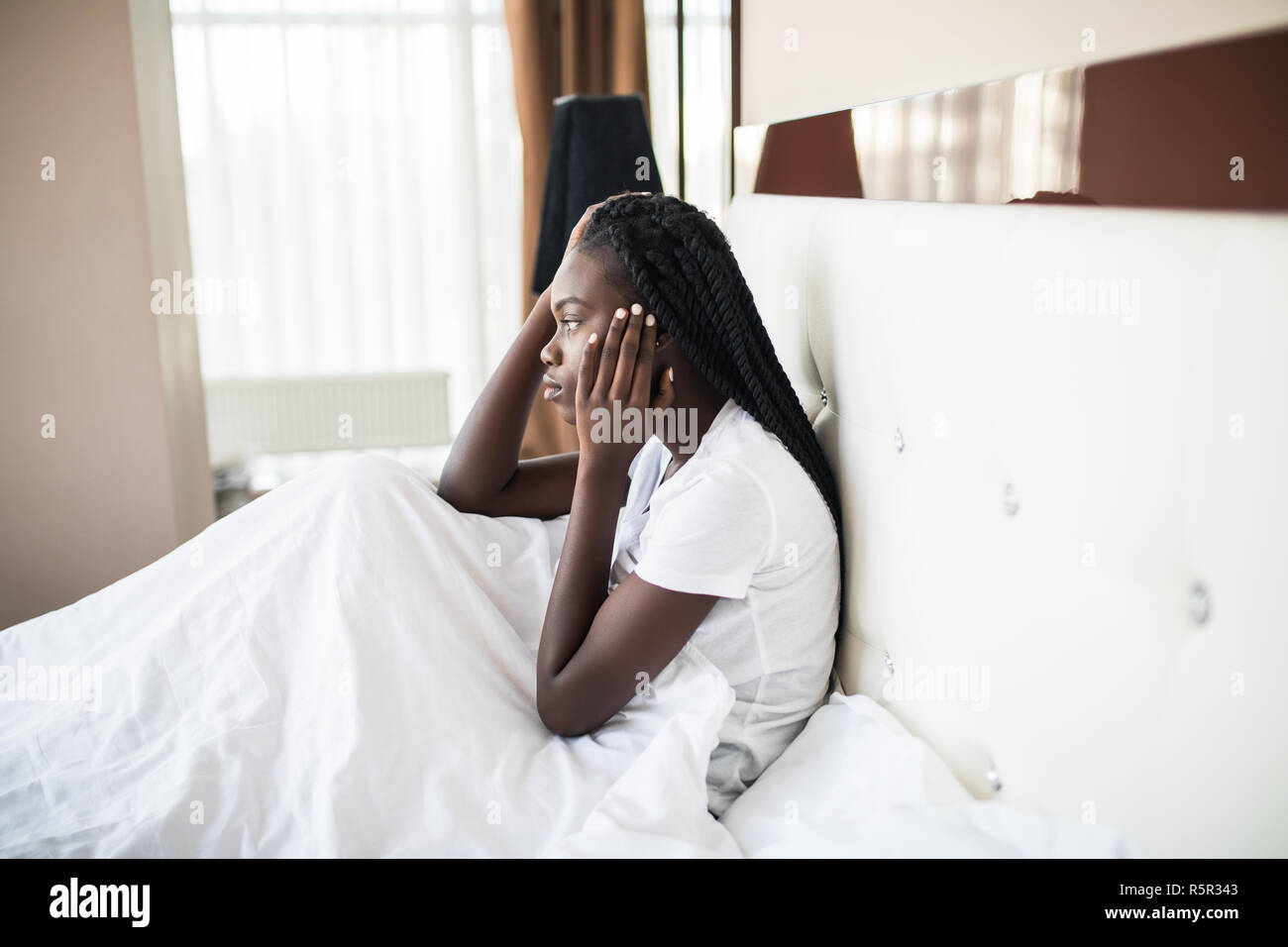 Headache, Depression, Restless Afro-American Woman Sleeping on Side Awaking from Sleep Stock Photo