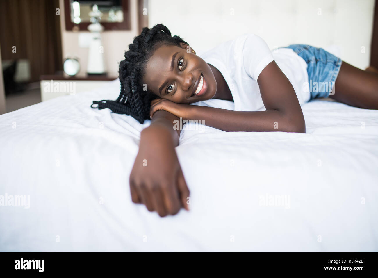 beautiful african american woman lying on bed Stock Photo - Alamy