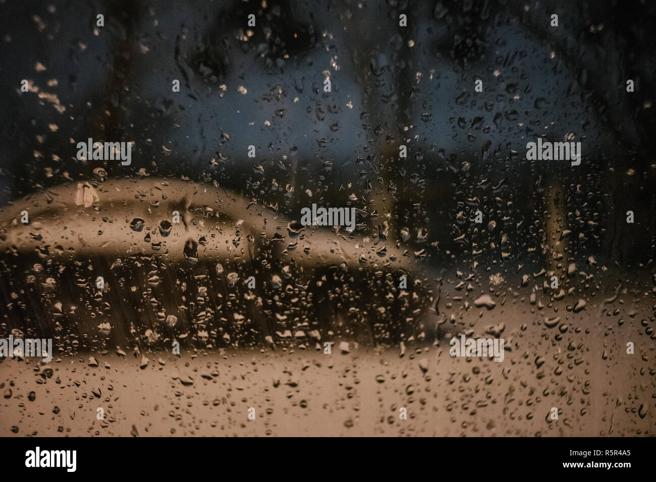 Water drops on car side glass in dusk Stock Photo
