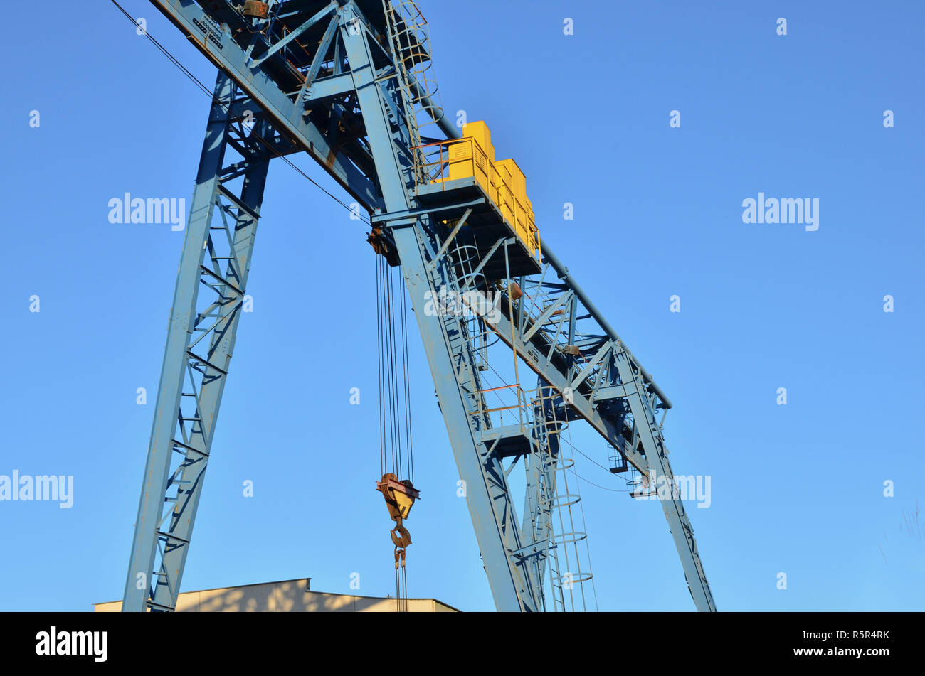 Gantry crane with hook for lifting and moving heavy cruz. Construction