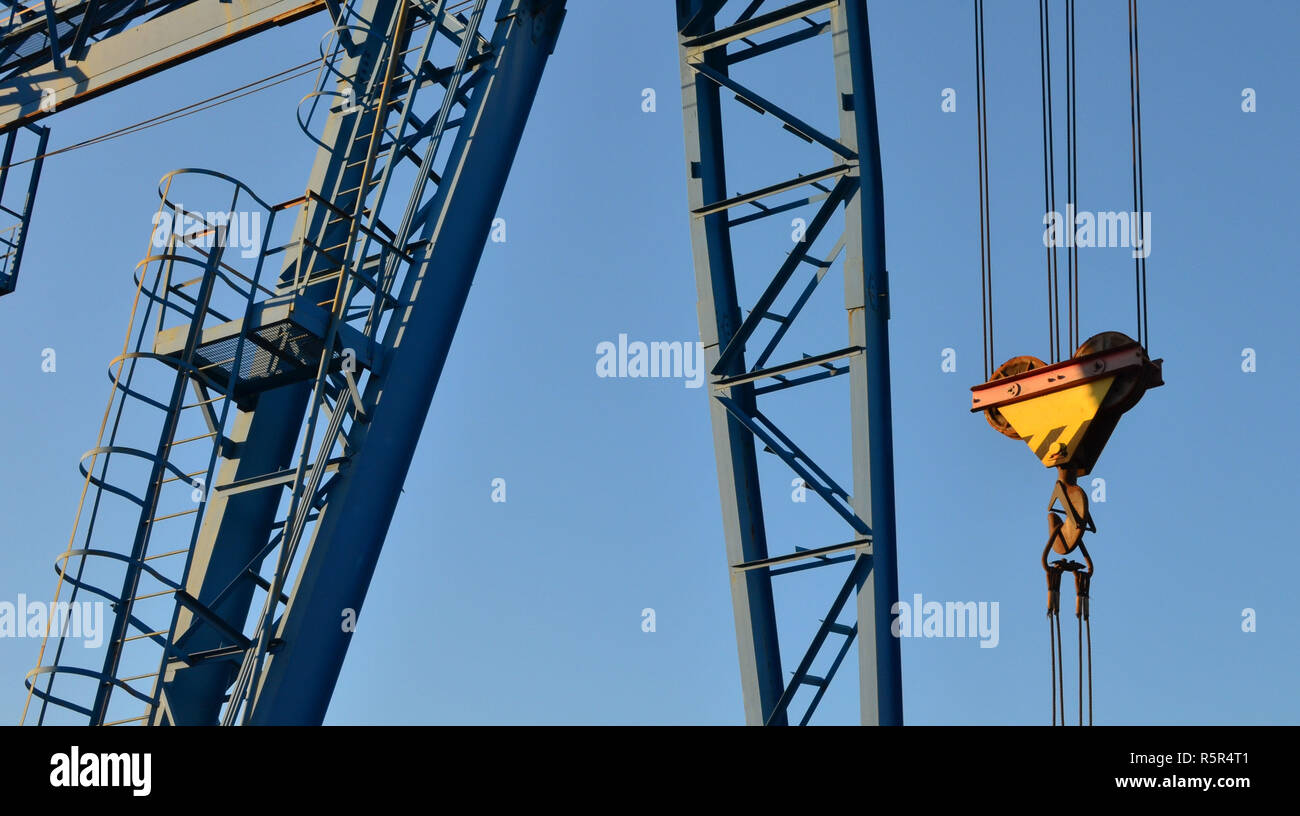 Gantry crane with hook for lifting and moving heavy cruz. Construction