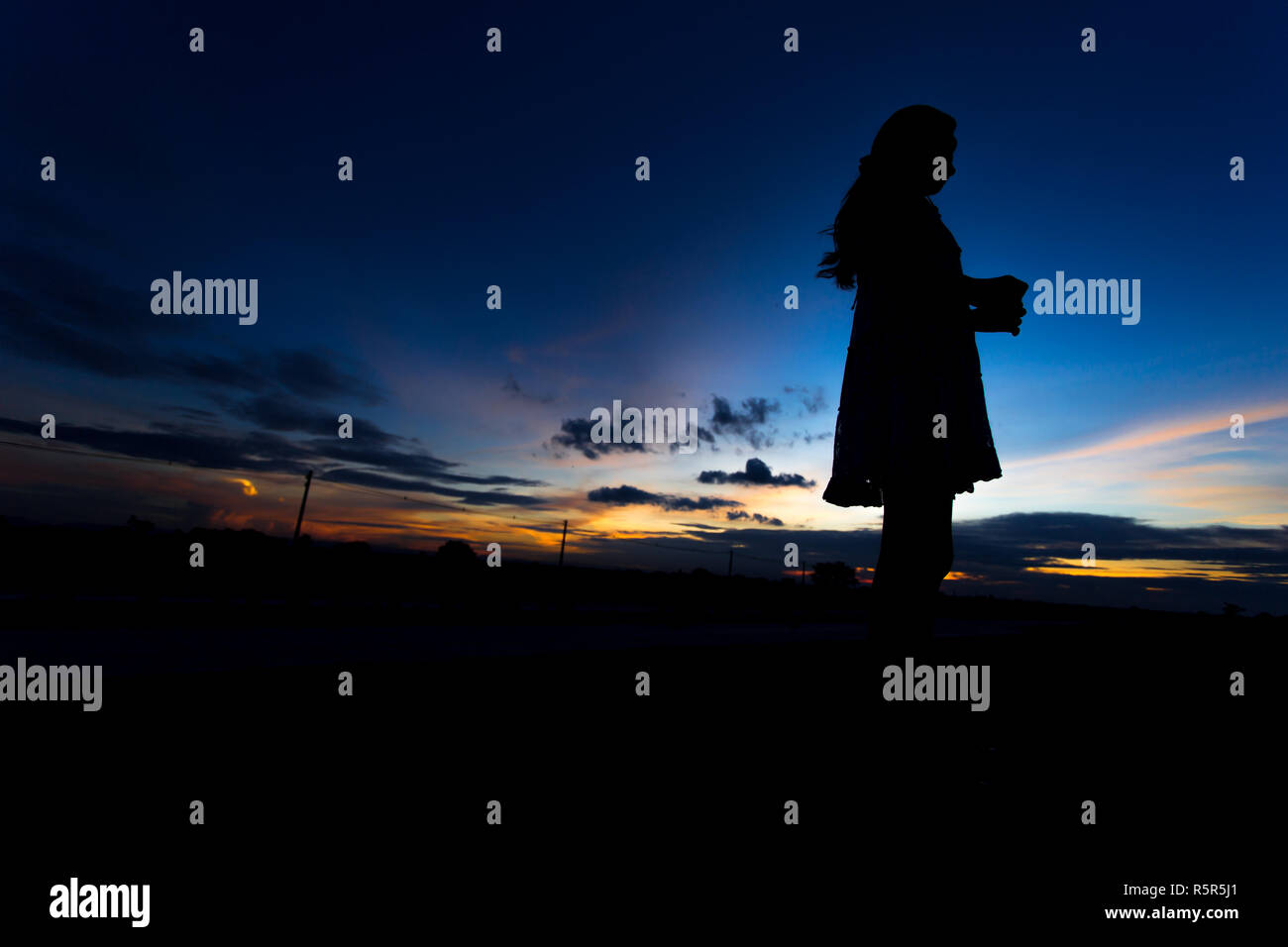 Silhouette of woman posing at sunset or sunrise Stock Photo - Alamy