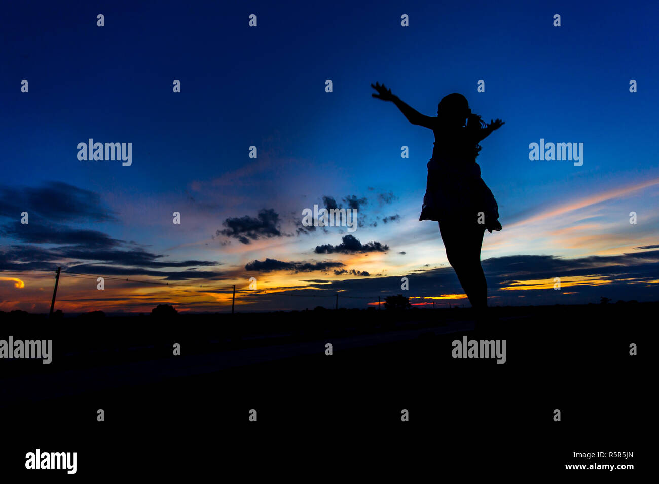 Silhouette of woman posing at sunset or sunrise Stock Photo - Alamy