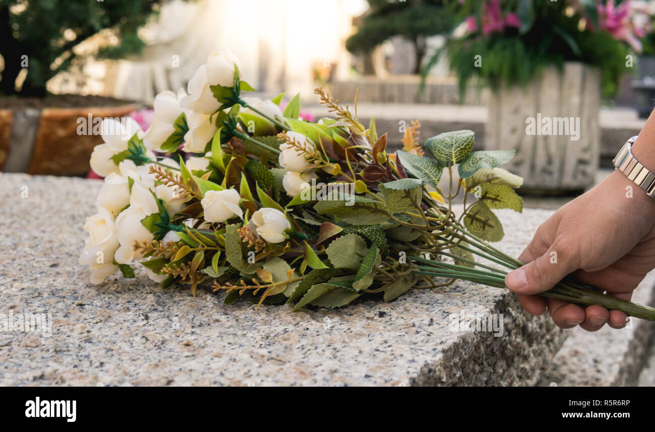Hand holds flowers on the coffin in the cemetery Stock Photo Alamy