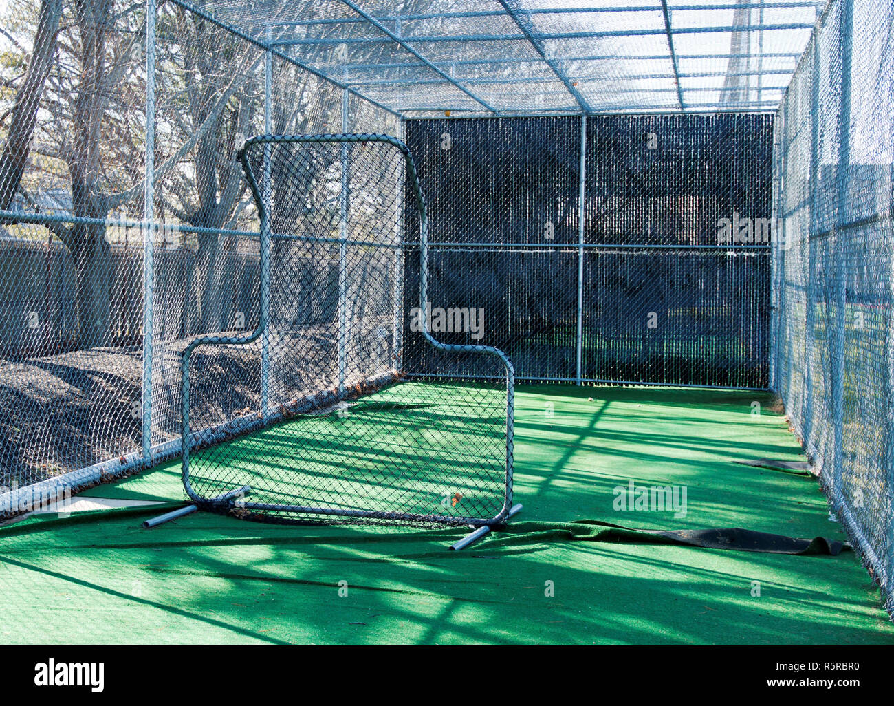 The view from inside a baseball batting cage from behind the pitching screen Stock Photo