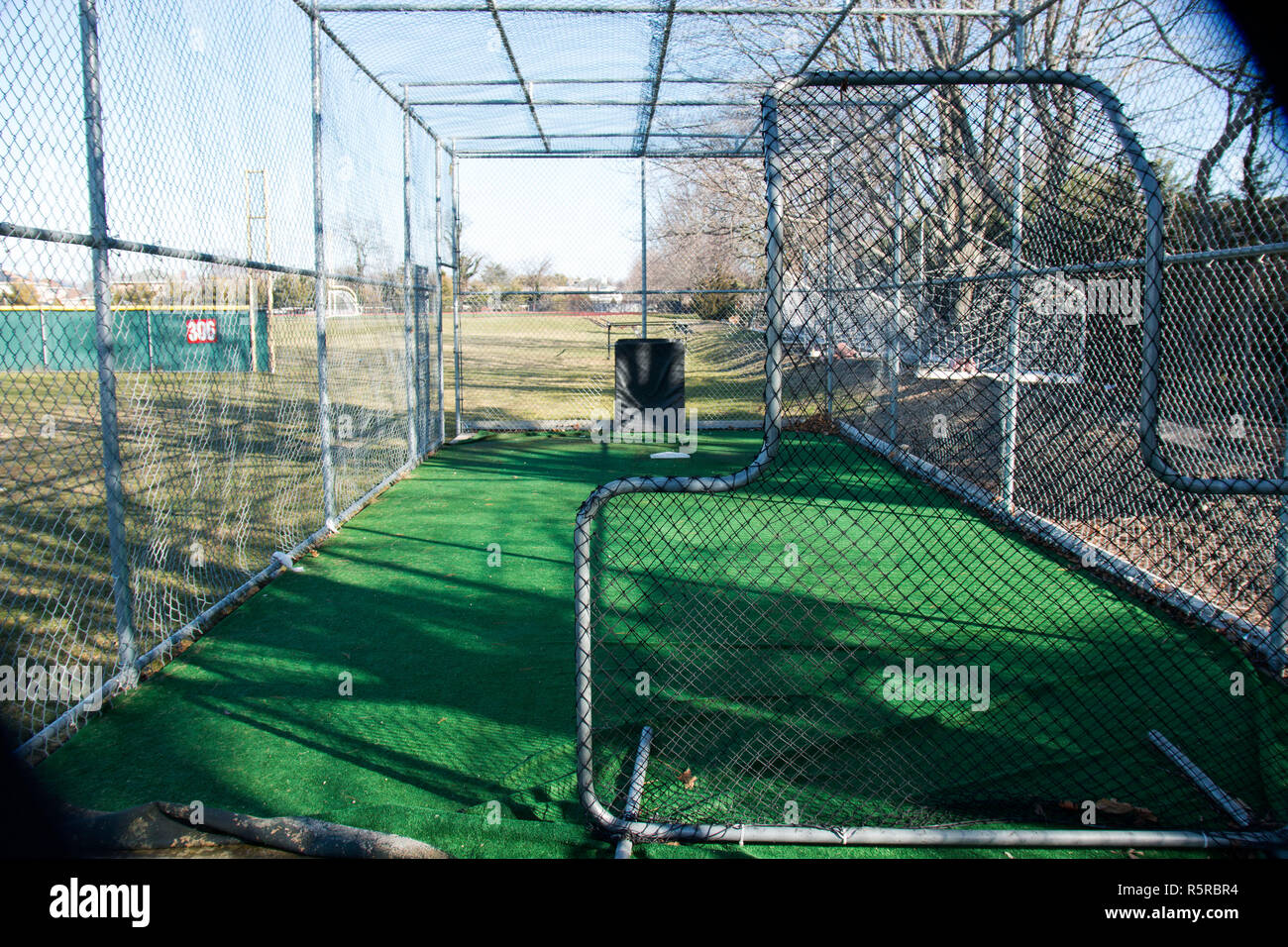 A local high schools batting cage from behind the pitchers safety screen Stock Photo
