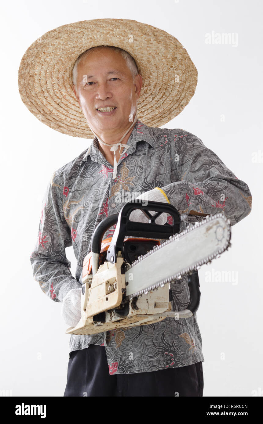 Asian old man holding chainsaw Stock Photo
