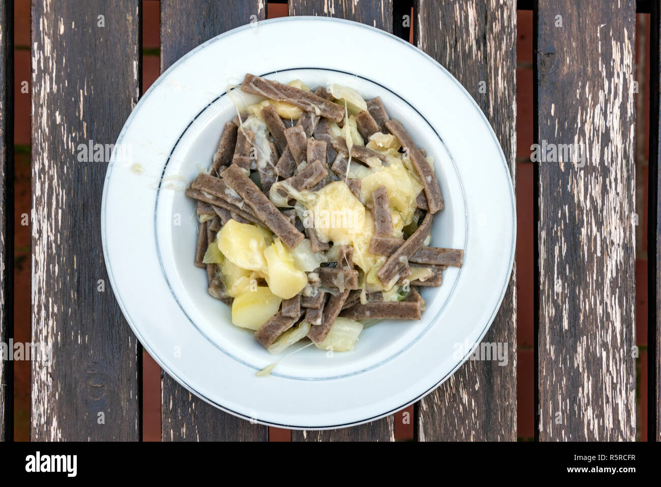 Pizzoccheri dish, a traditional short tagliatelle pasta typical of northern Italian province of Valtellina, Italy Stock Photo