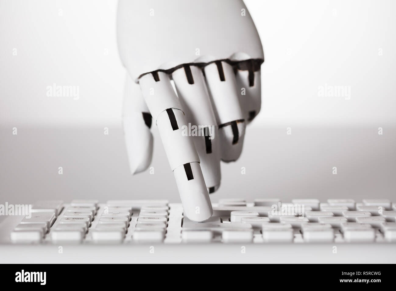Robotic Hand Pressing Enter Key Stock Photo
