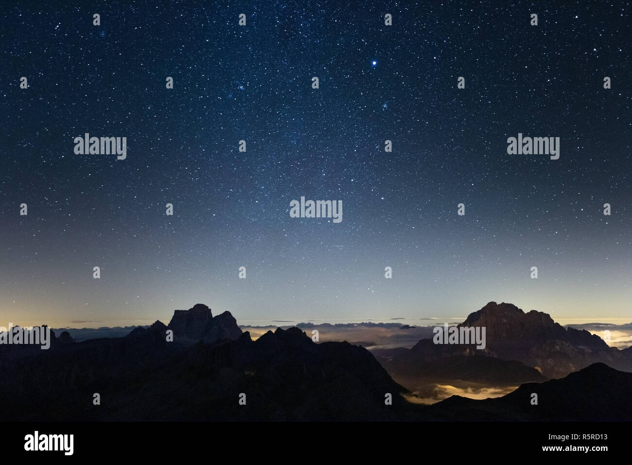 Starry sky above the Dolomites. Mountain layers. Night sky, stars. Night landscape. Italy, Europe. Stock Photo