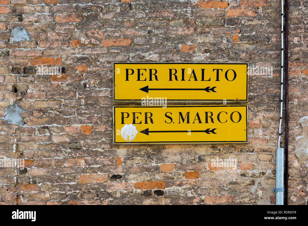 Venice wall mounted direction signs with arrows to Rialto and San Marco Stock Photo