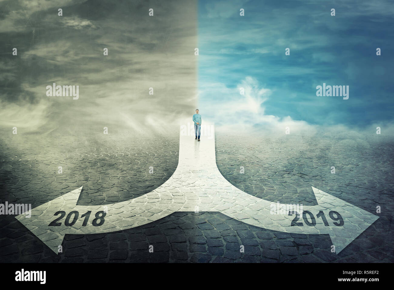 Man walk in front of a crossroad splitted in two different ways as arrows to stay in the 2018 year or move to 2019 new life challenge. Choosing correc Stock Photo